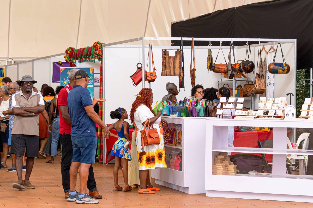 Patrons checking out the arts and crafts on display and sale at the Grand Market at CARIFESTA XV in Barbados.