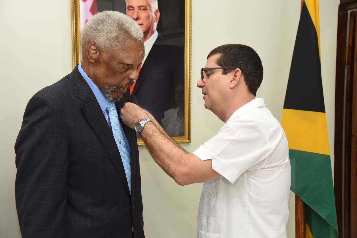 Cuban Ambassador Fermín Quiñones pins Errald Miller, husband of former Pime Minister Portia Simpson Miller, with the Cuban Medal of Friendship, one of Cuba’s highest honours for foreign leaders who have supported the country.