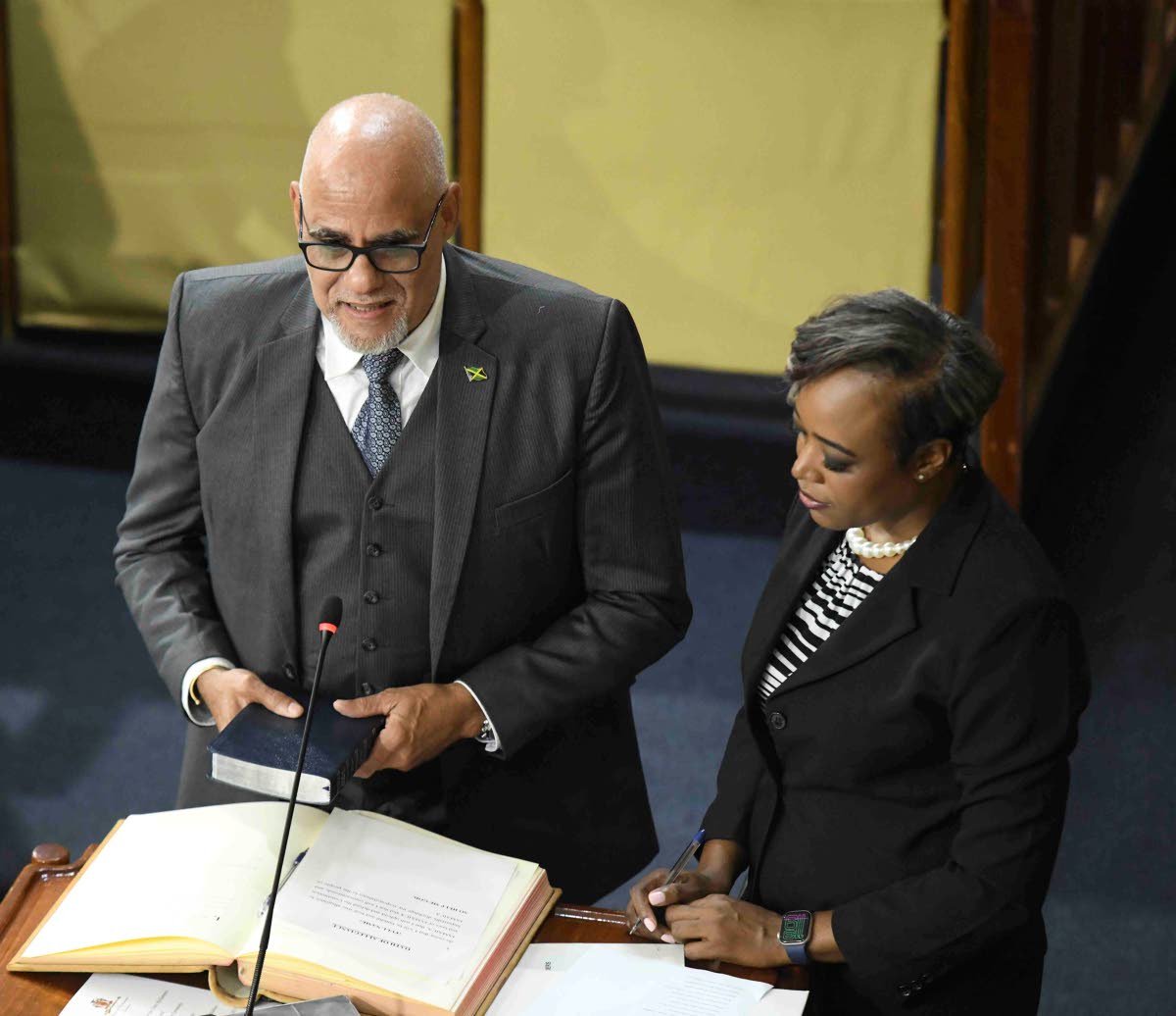 House Clerk Colleen Lowe (right) administers the oath of allegiance as Keith Duncan is sworn in as a government senator in Gordon House on Thursday.