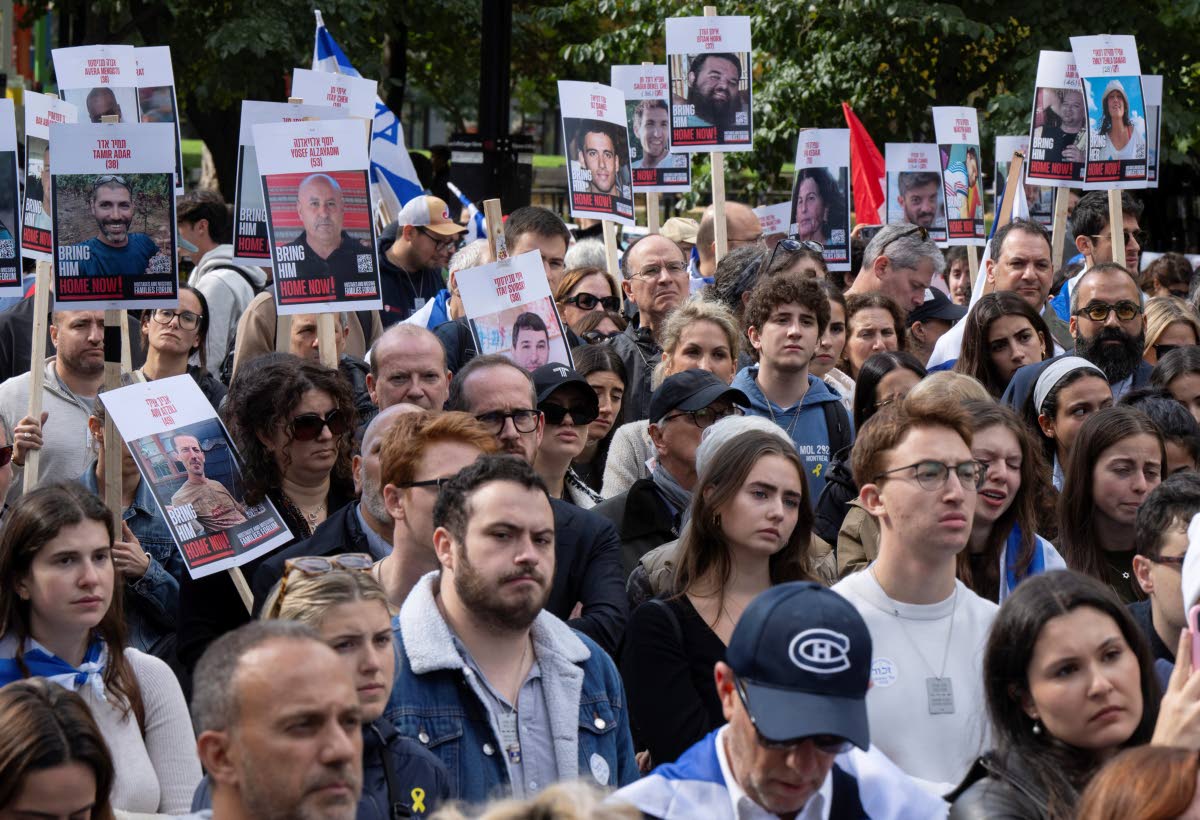 People hold pictures of hostages as they attend a pro-Israel vigil on the anniversary of a Hamas attack on Israel that triggered the ongoing war in Gaza in front of McGill University in Montreal, Canada on October 7, 2024.