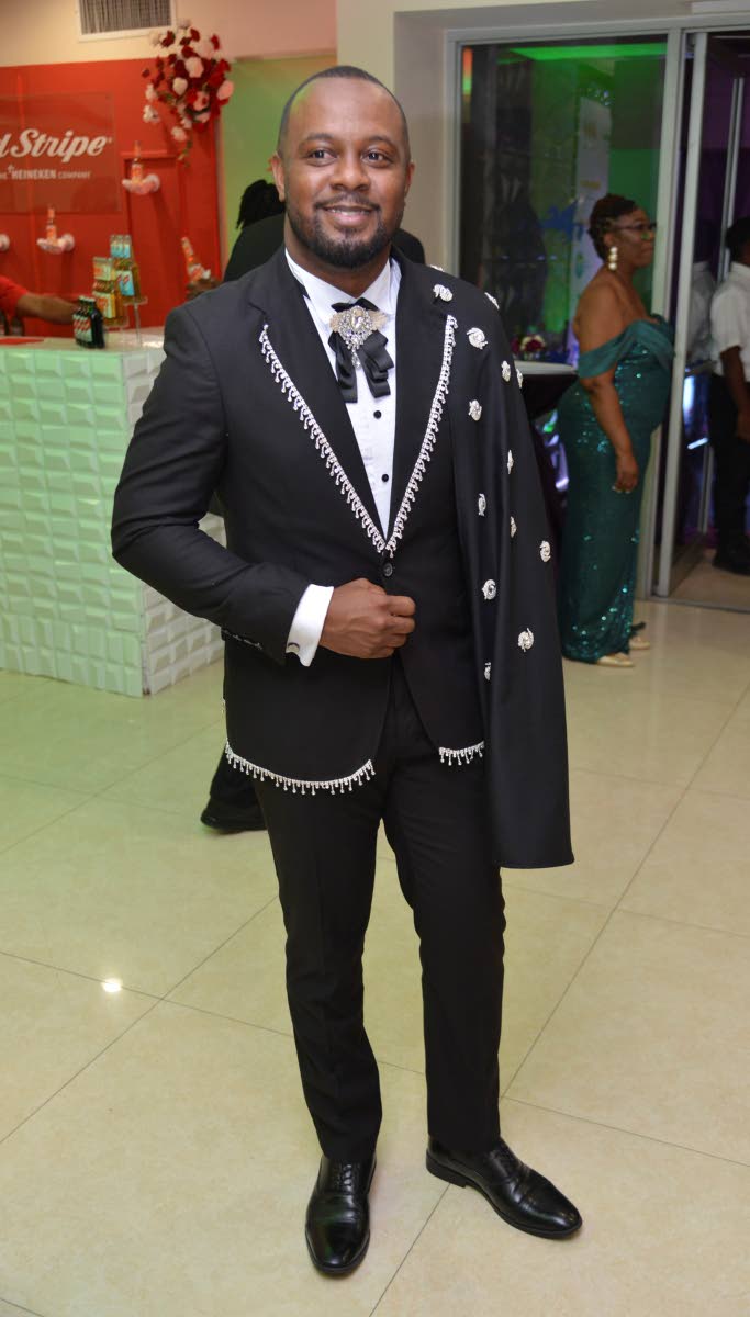 Alex Sterling wears a black suit with embellished edges and a cape by Sophia Jones Designs.