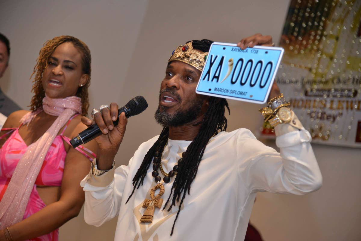 LA Lewis holds up one of several licence plates that were unveiled for use on vehicles owned by the Nyan-Ko-Pong: Sovereign Maroons. 
