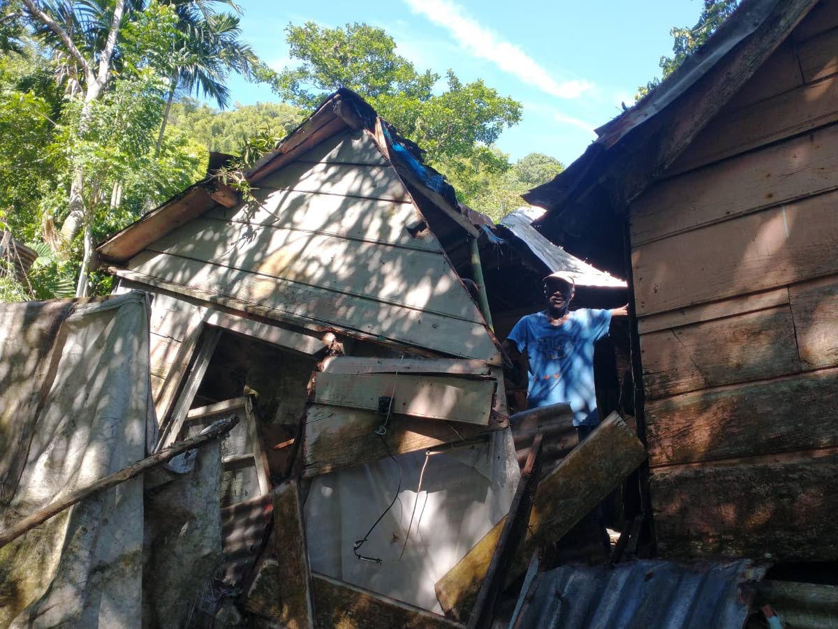 Rudy Campbell looks out from a gaping hole in a section of his home, which was damaged when a huge guinep tree fell on it during adverse weather just over a week ago in Castleton, St Mary.