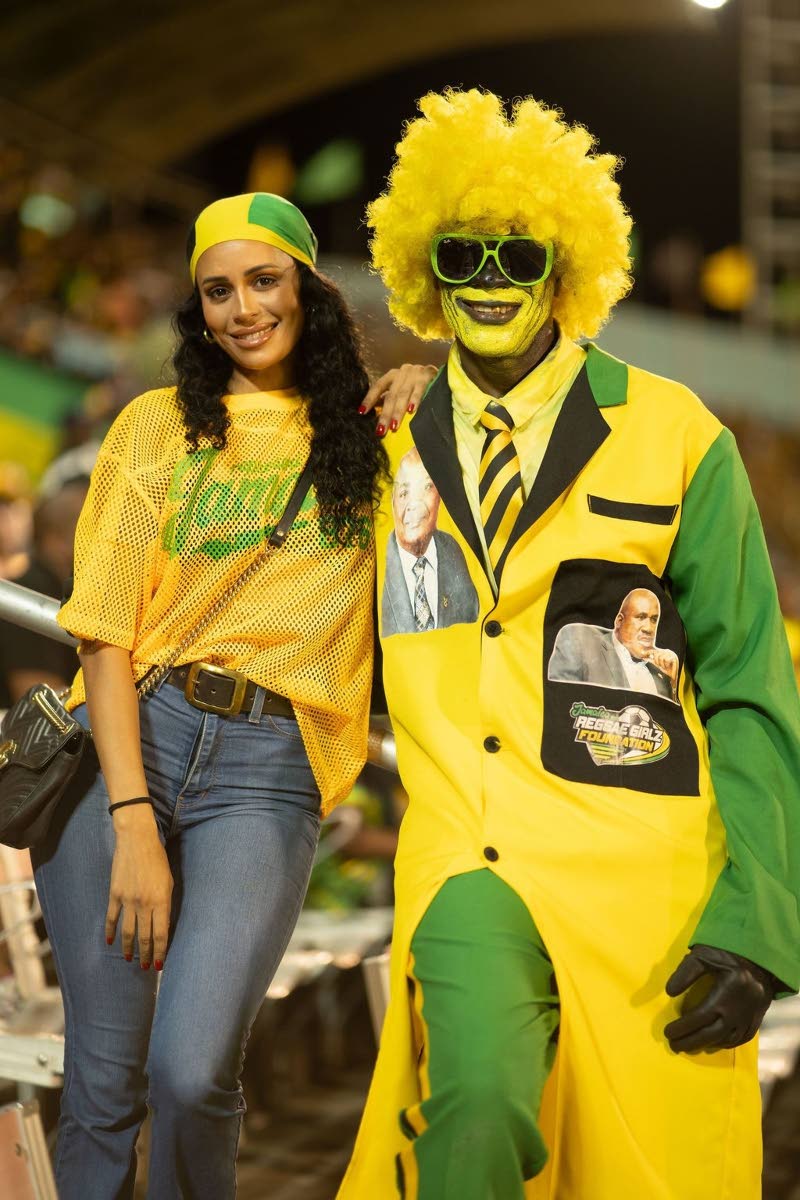 Gabrielle ‘DJ Gabby’ Davis (left) strikes a pose alongside Reggae Boyz Mascot, Wally Walters. 