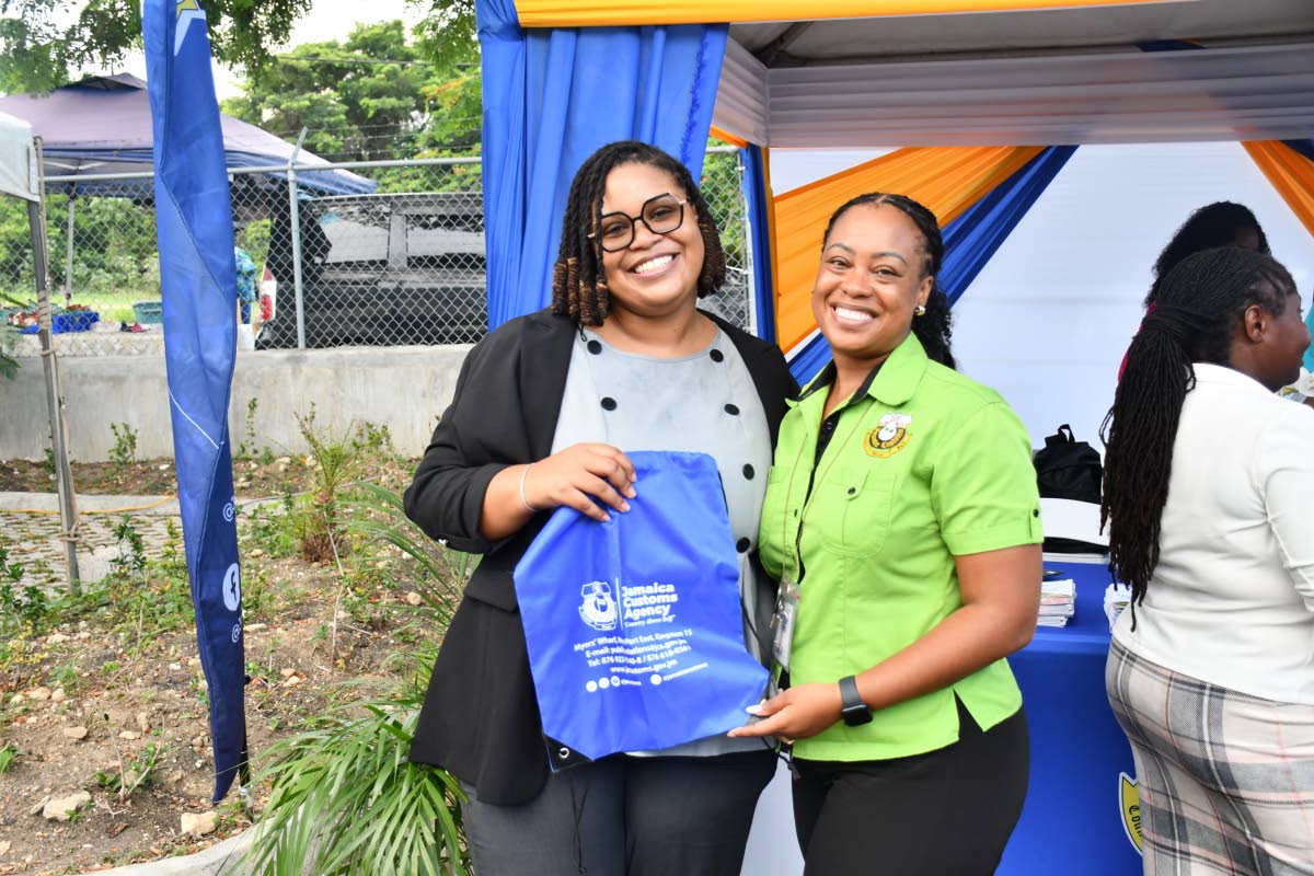 Judiciary of Jamaica’s Jaya Kamoze is all smiles as she goes home with more than Customs information. Handing her the token is JCA Legal Officer Trichana Gray Nicholson (right).