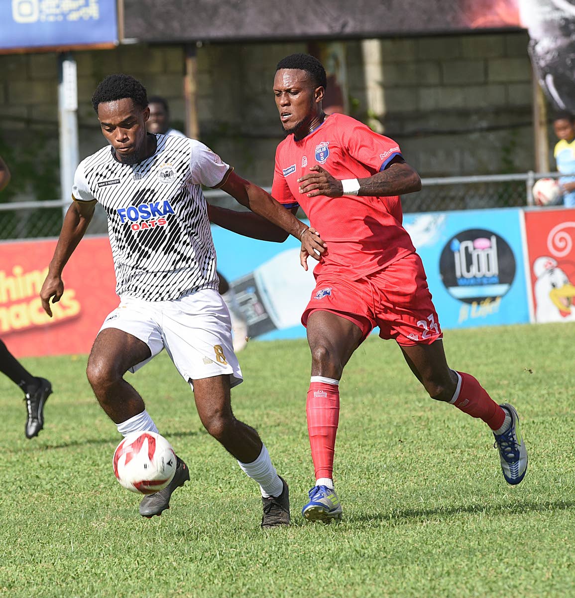 Adrian Reid (left) of  Cavalier dribbles clear of Diamond Clarke of Spanish Town Police FC during their Jamaica Premier League match at the Waterhouse Mini Stadium yesterday.