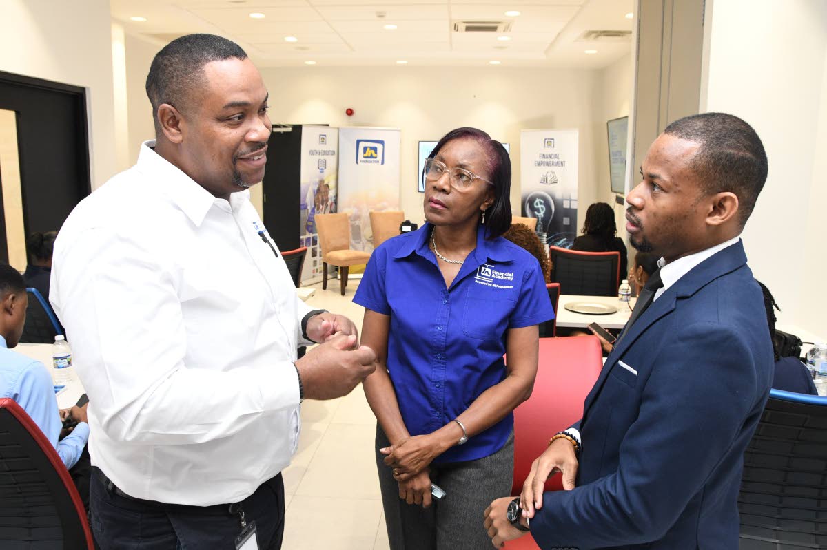 Keith Parkes (left), business development manager at CRIF Information Bureau Jamaica, in discussion with Rose Miller (centre), financial education consultant with the JN Foundation, and Devrhoid Davis, financial risk analyst at the JN Group. They were atte