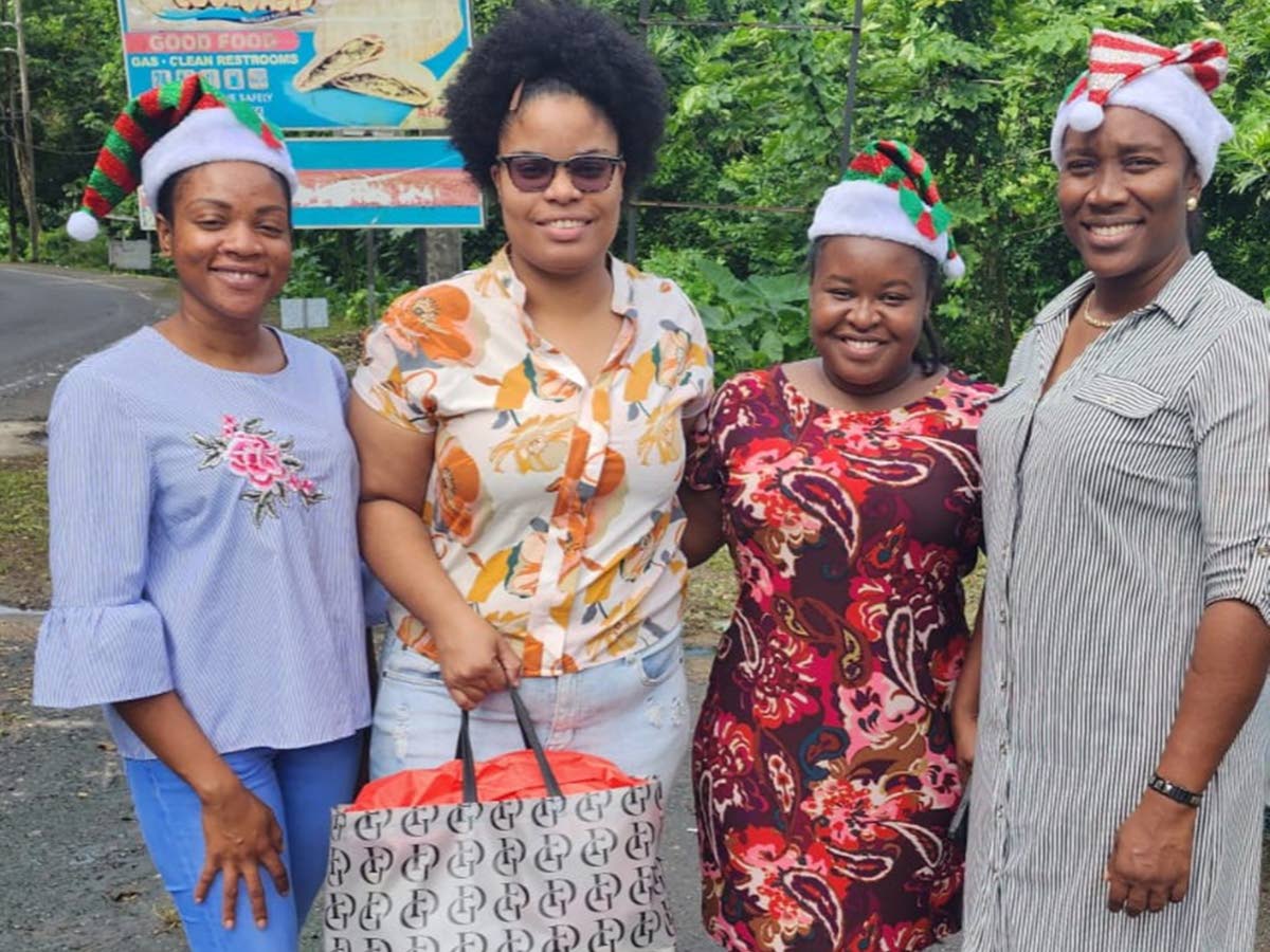 An unnamed parent (second left) poses with guidance counsellors (from left) Yolisa Passley, Imani Gordon, and Tena Williams-Leslie, during the Holiday Helpers’ annual treat in 2023.