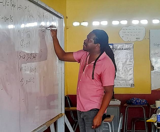 Damion Crawford, member of parliament for St Catherine North Western goes through a math equation during one of the math classes in hosts at Charlemont High School in Linstead, St Catherine on October 18.