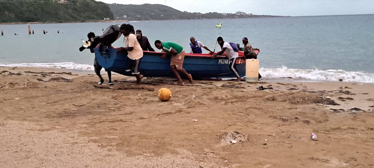 Left: Fishermen in Port Maria bringing their vessel to shore.