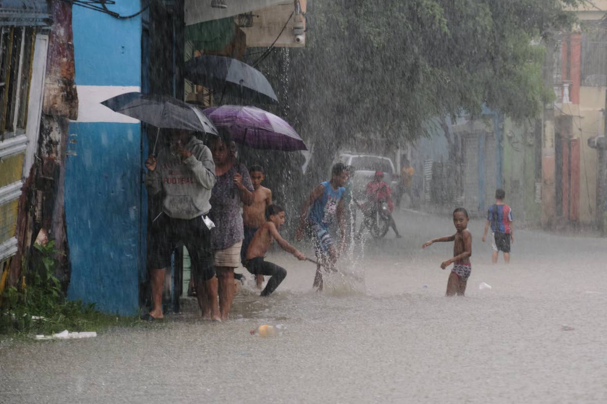 Children playing in a street flooded by rains caused by Tropical Storm Melissa in Santo Domingo, Dominican Republic, on Friday, October 24.