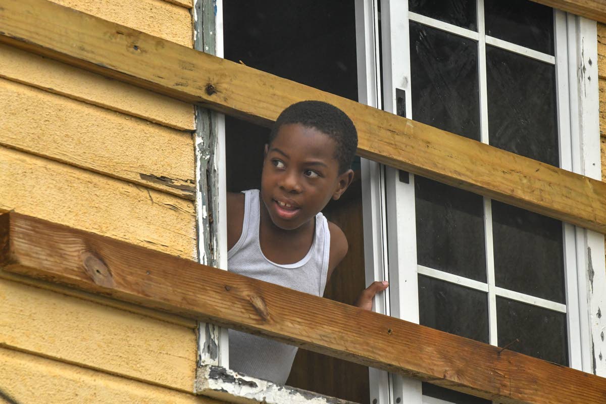Eight-year-old Chase Daley looks out his window as the rain falls in Port Royal as Hurricane Melissa approaches the island yesterday.