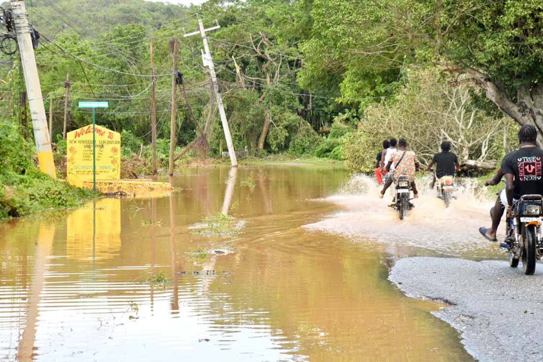 Residents of Big Pond, Old Harbour traverse a main road in the area following Hurricane Melissa on Wednesday.