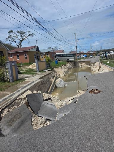 Above: This damaged road in The Estuary, St James, was a chilling sight on Wednesday afternoon. Residents of that community were reportedly marooned due to both entrances into the community being blocked by fallen trees and a damaged bridge.