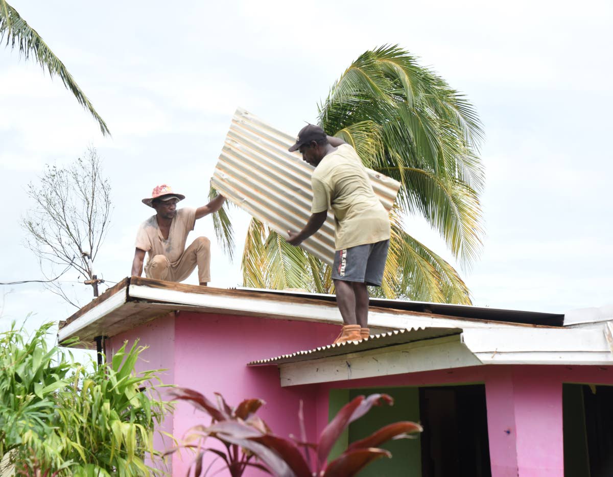 Edwin Powell (left) and Anthony Powell repair the roof of a neighbour in Bull Savanna, St Elizabeth after Hurricane Beryl in 2024.