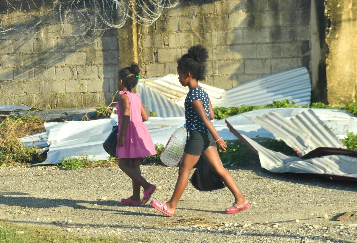 Children in Westmoreland going to collect water on Friday, following Hurricane Melissa.