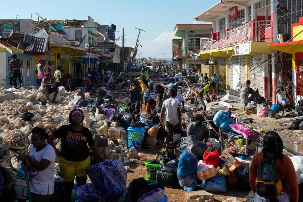 Residents gather amid debris in the aftermath of Hurricane Melissa on a street in Black River, Jamaica, Thursday.
