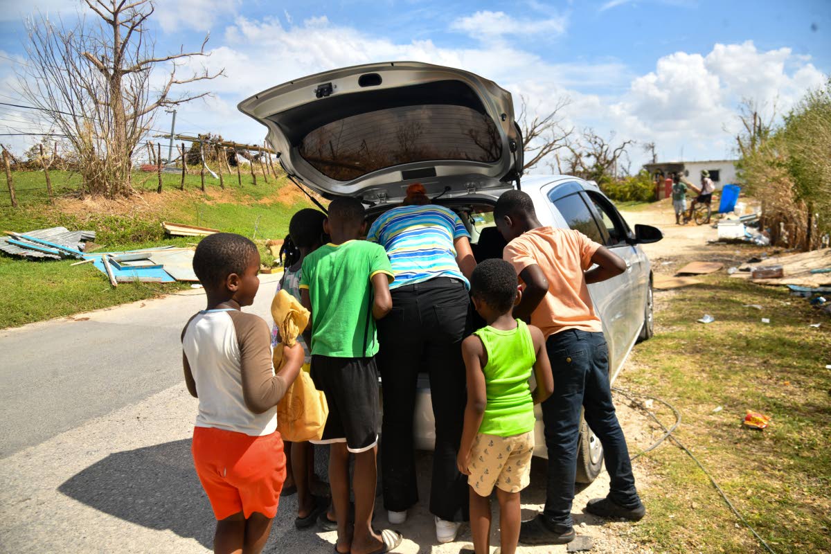 Children gather around to get porridge in Oxford, St Elizabeth.