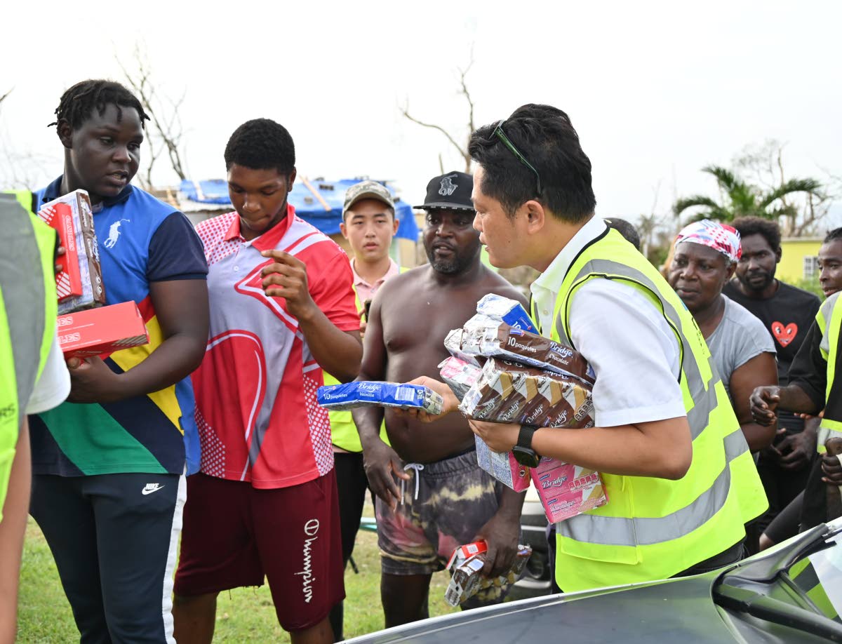 Businessman Yucheng Tao (right) is seen distributing care packages to residents of Shrewsbury Logwood in Westmoreland.