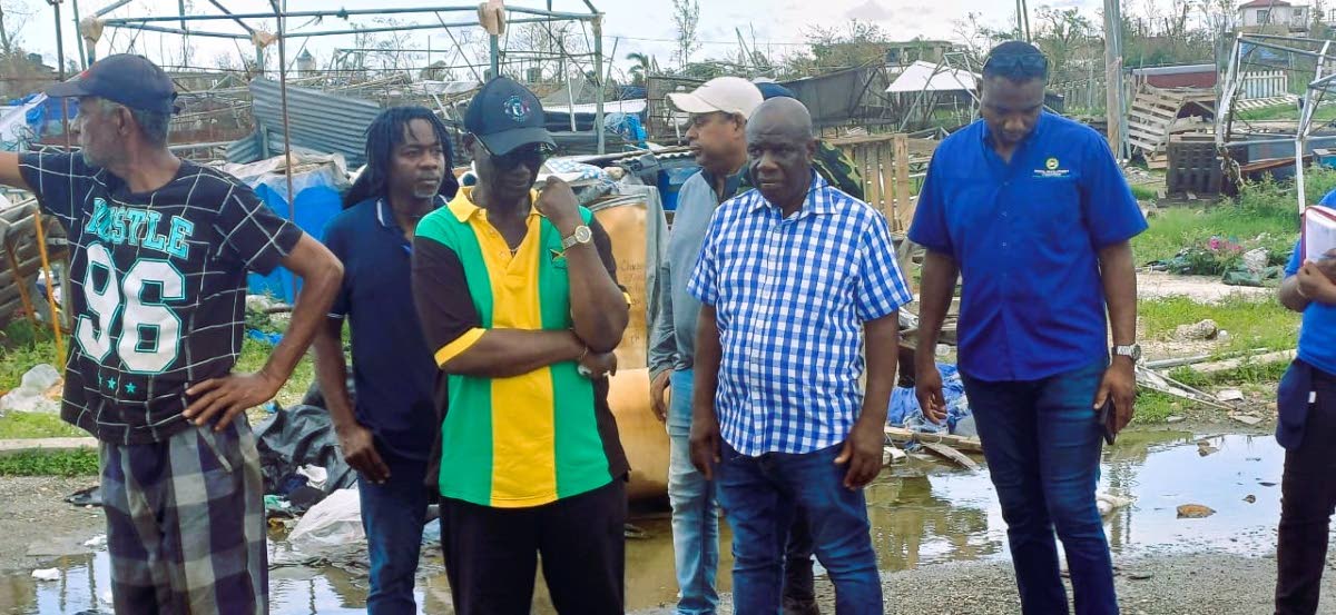 Minister of Local Government, Desmond McKenzie (2nd left) and Mayor of Falmouth, Collen Gager (right front) tour the town of Falmouth with other technocrats in the government and vendors displaced by Hurricane Melissa.
