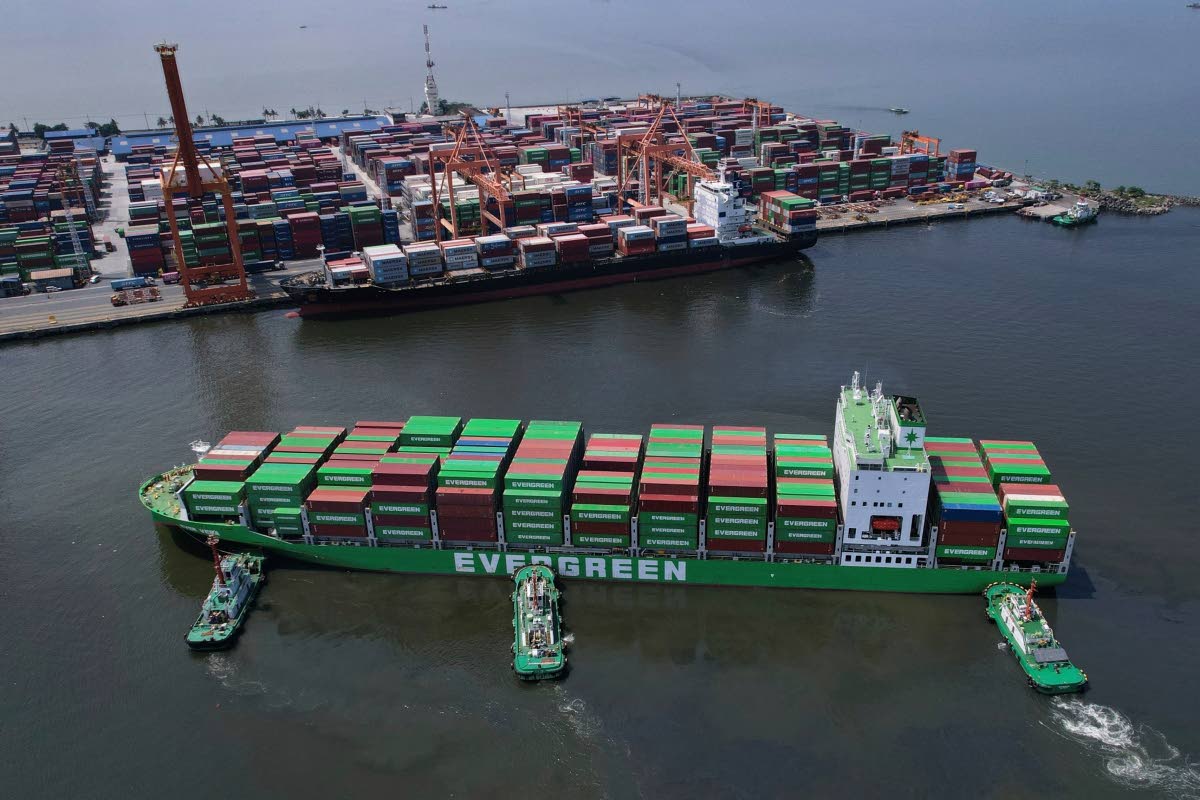 Tugboats assist a container ship as it prepares to dock at the Manila International Container Terminal at the Philippine capital on April 8, 2025.