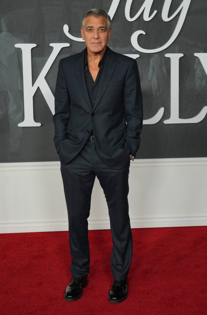 George Clooney walks the red carpet in a dark suit sans the tie. 