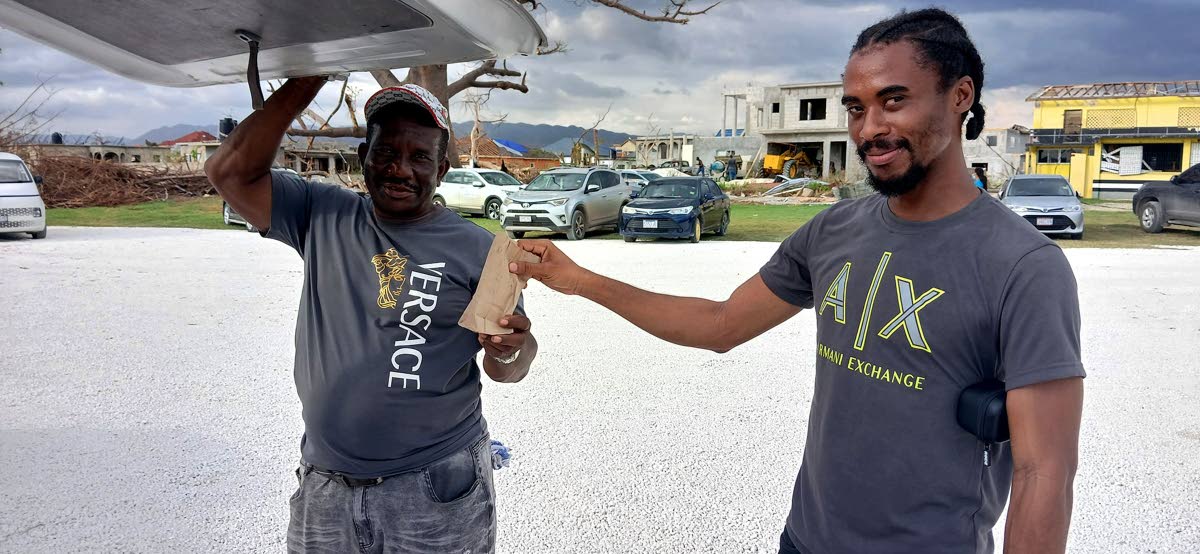 Earl Whyte, left, shares a patty on November 11 at the field hospital in Black River operated by Samaritan’s Purse in St Elizabeth.
