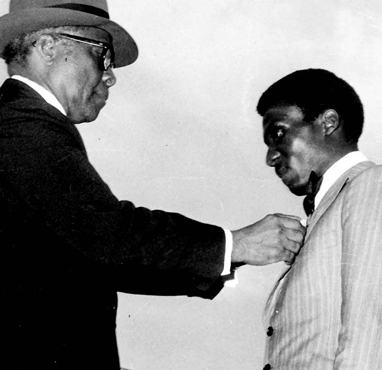 Sir Florizel Glasspole presents Jimmy Cliff with the insignia of the Order of Distinction (Officer) at the National Stadium in October 1973.