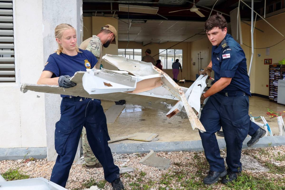 Specialist personnel from the Royal Navy’s HMS Trent assisting hospital workers clearing the debris at Falmouth Hospital in Trelawny.
