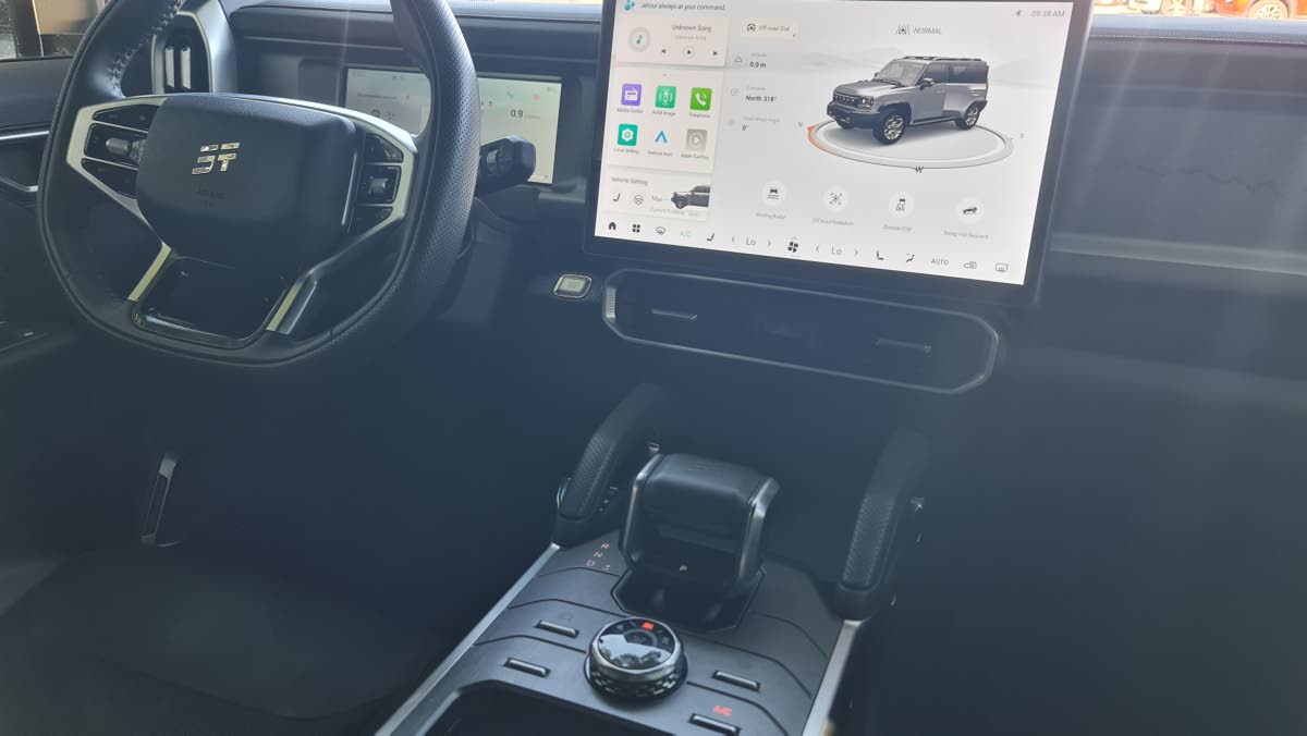 The high-resolution 15.6-inch infotainment screen dominating the dashboard, providing access to all vehicle functions and media.