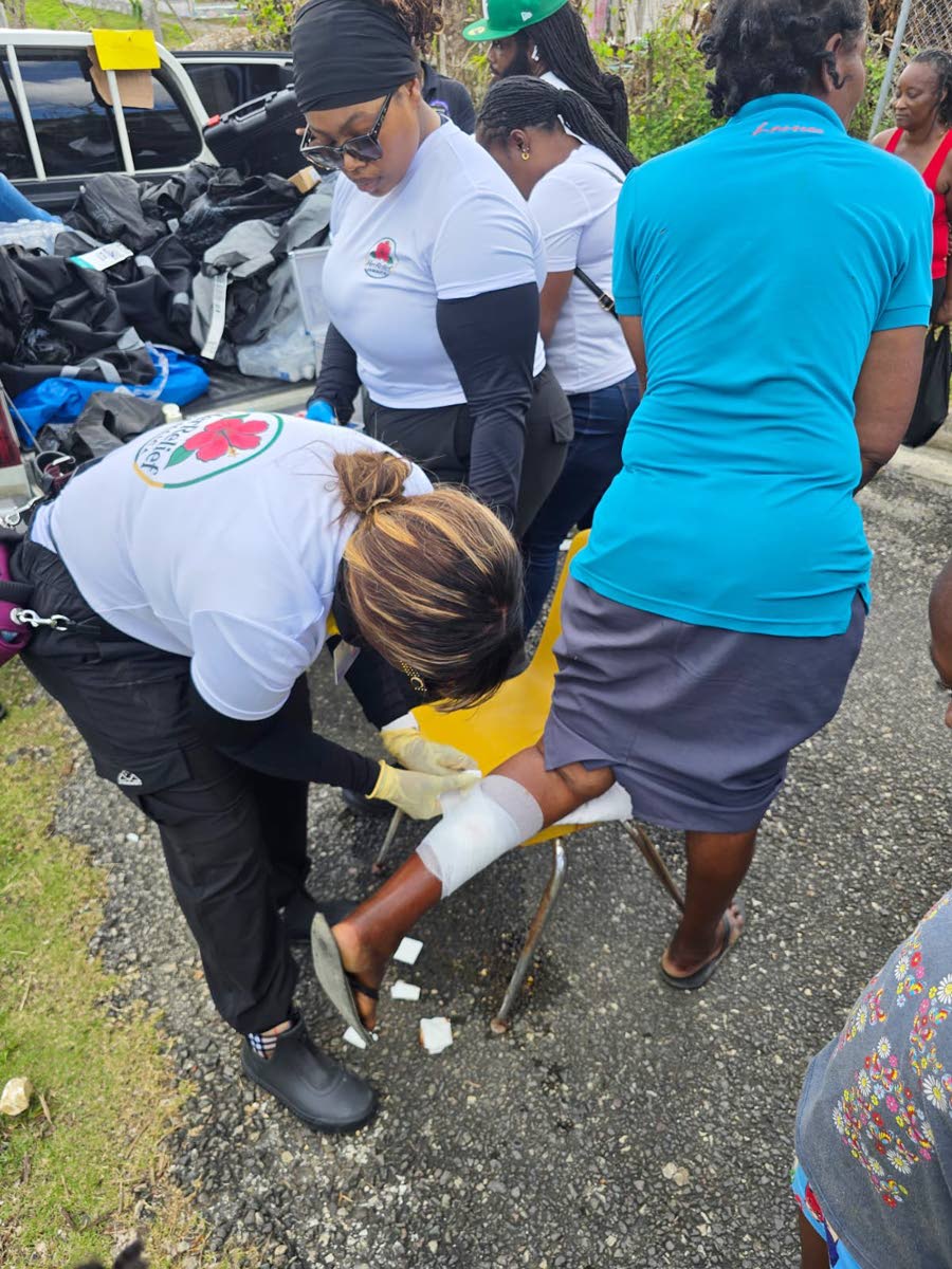 Dr Kerone Thomas, co-founder and medical director of the Her Relief Jamaica Foundation, treats a resident’s injured foot during the group’s first mission to Jamaica after Hurricane Melissa.