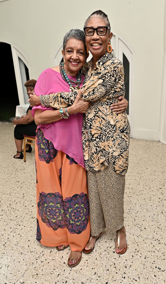 Beverley Manley Duncan (right) pulls Sandra D. Cooper in for a warm, congratulatory squeeze.