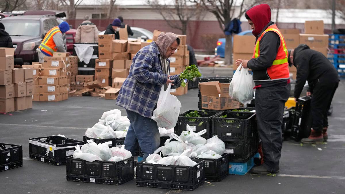 
Utah Food Bank volunteers gather groceries for the needy at a mobile food pantry distribution site on December 21, 2022, in Salt Lake City.
