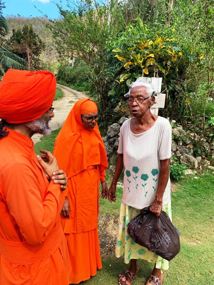 From left: Acharya Giitisudhananda Avadhuta, principal of Ananda Marga Kinder–Prep School, and Didi Ananda Devaprana Avadhuta, principal of the Ananda Marga Basic School are seen distributing relief materials.