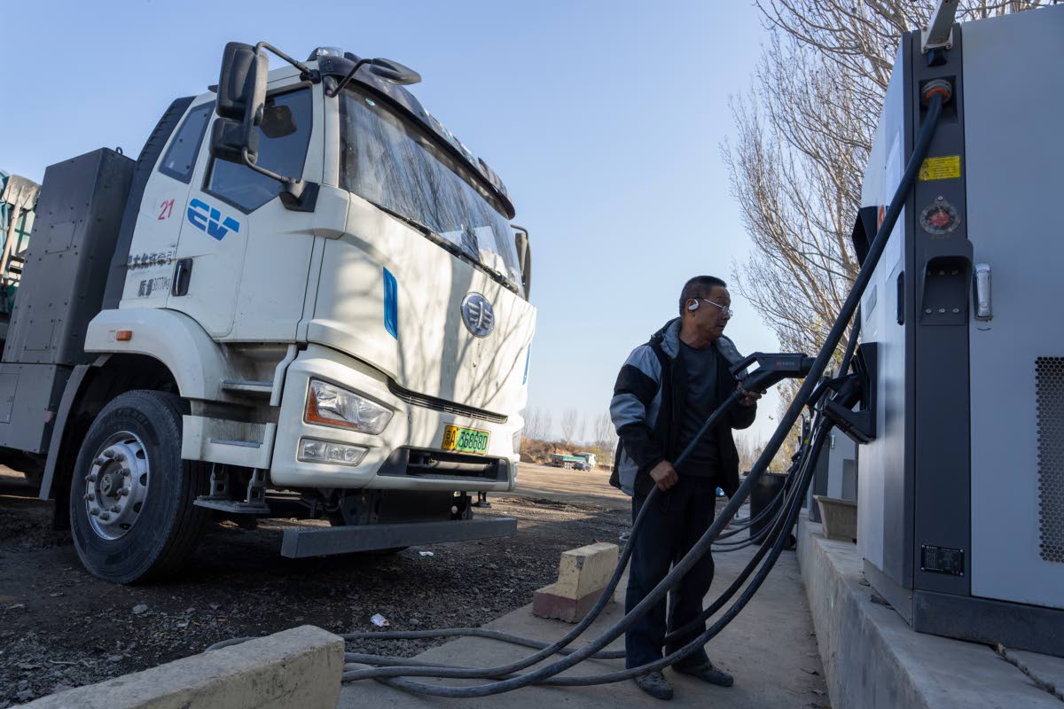 
A driver charges his electric truck at a charging station on the outskirts of Beijing, on November 14, 2025.
