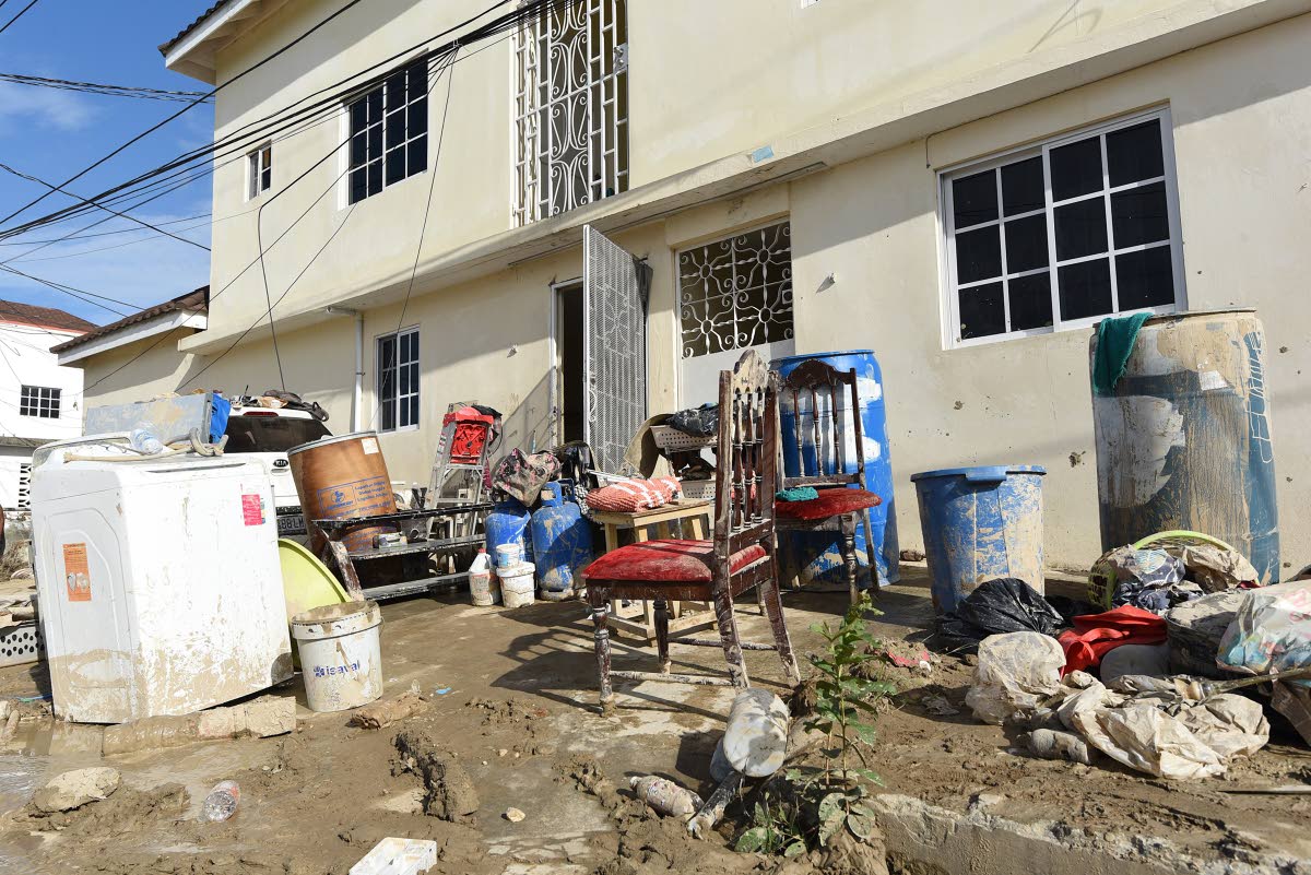 Ian Allen/Photographer 
Belongings are seen piled up on a street filled with mud in a section of Catherine Hall Montego Bay, St James, which was affected by Hurricane Melissa.