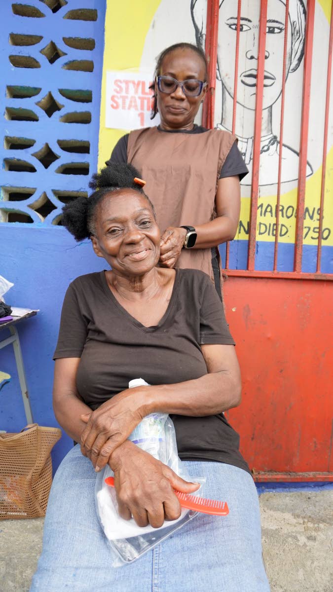 ABOVE: A United4GoodJA volunteer styles the hair of a shelter 
resident in Westmoreland.