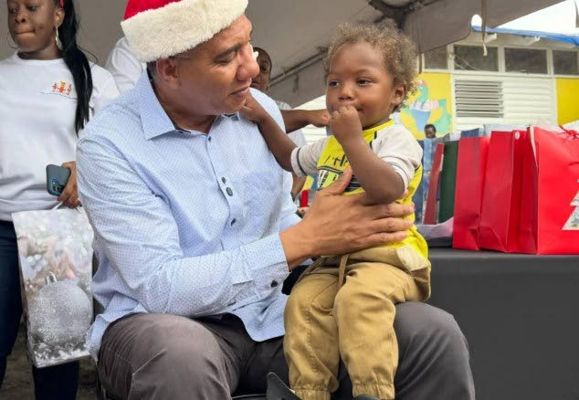 Prime Minister Dr Andrew Holness interacts with a young child at a Christmas kiddies treat at the Middle Quarters Primary and Infant School in St Elizabeth on December 13, 2025.