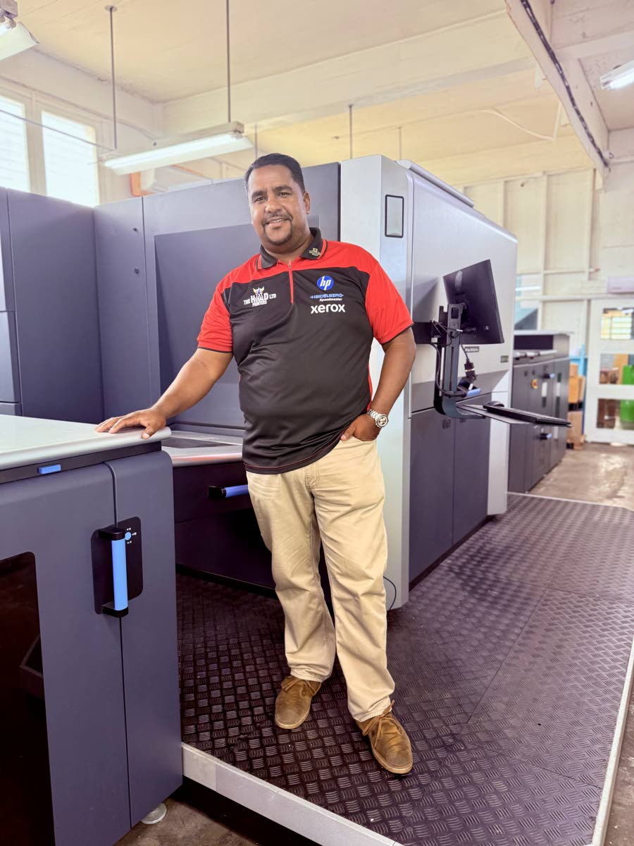 Rodger Brown standing on the latest acquisition of HP Indigo 15K Digital Offset Press