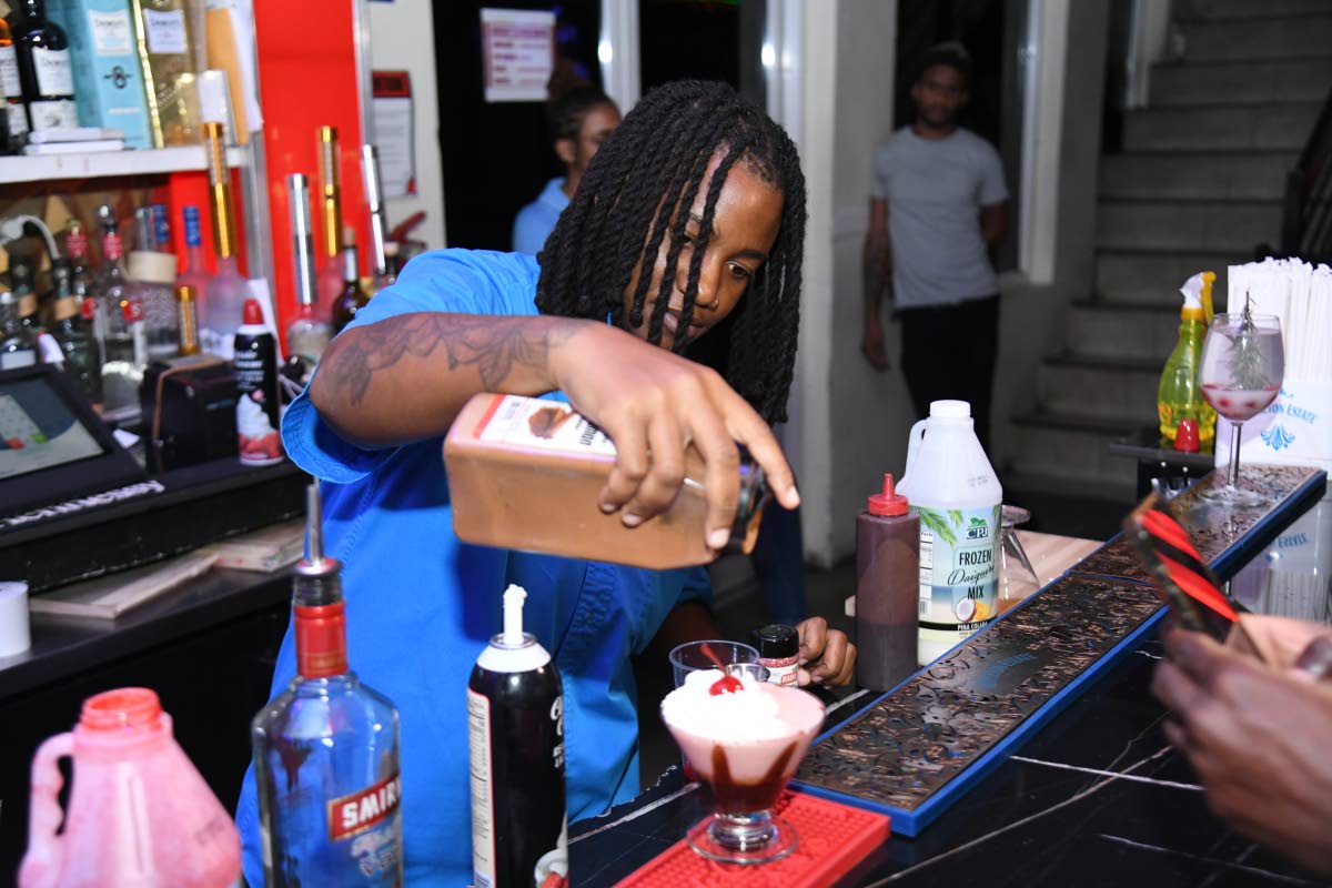 Mixologist Shanae Williams adds final sprinkles of cinnamon to her signature Santa’s side sip. 