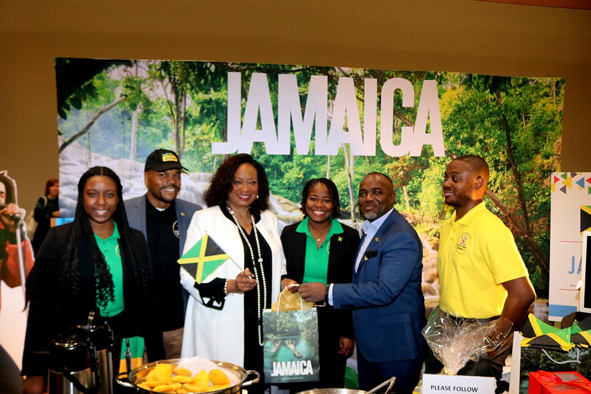 Secretary of the District of Columbia, Kimberly A. Bassett (3rd from left) receives a gift from Jamaica Tourist Board (JTB) business development officer for Northeast USA, Ricardo Henry, after she toured Jamaica’s booth at Winternational   embassy showca