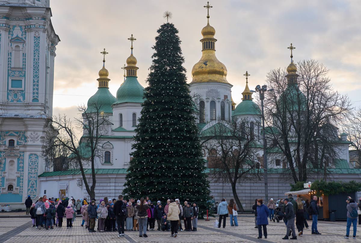 People walk around the Christmas tree in front of St. Sophia Monastery in central Kyiv, Ukraine, Wednesday, Dec. 10, 2025.