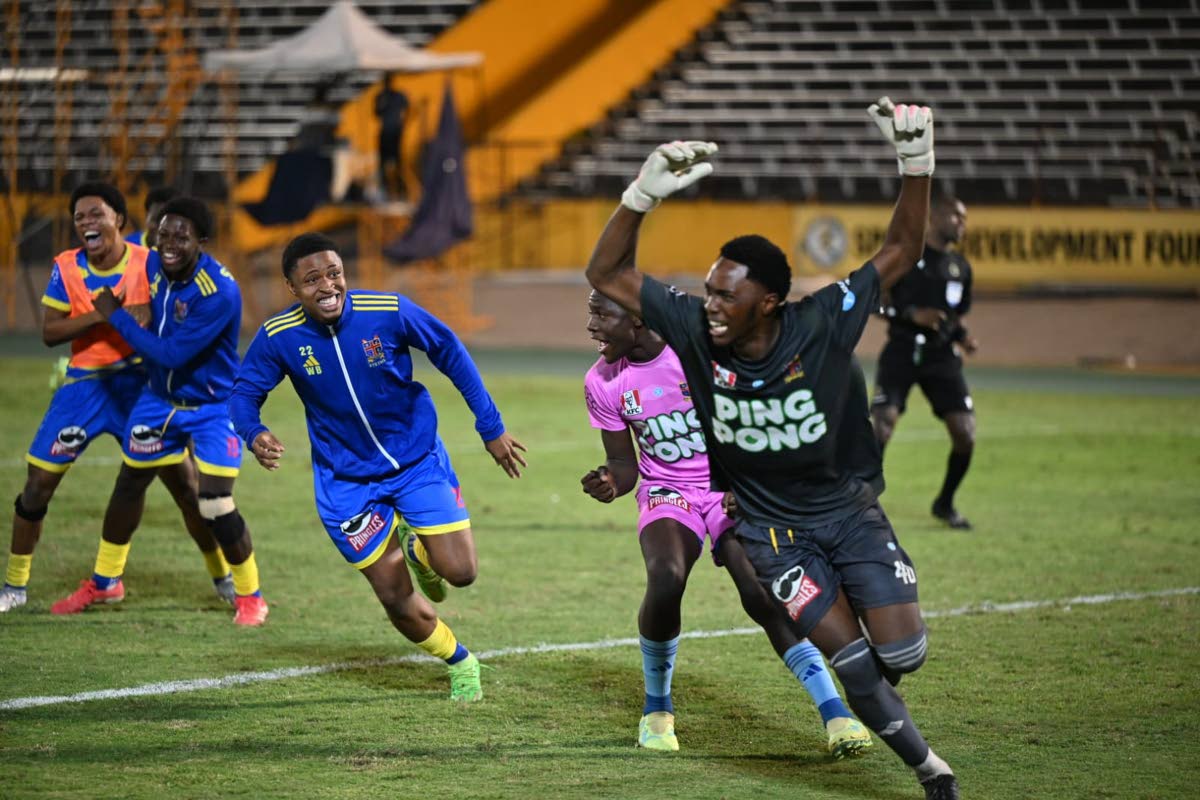 St Elizabeth Technical High School goalkeeper Johnoi Steadman is mobbed by teammates after making the decisive penalty save to secure the 2025 daCosta Cup title against Glenmuir High School on December 20, 2025. 