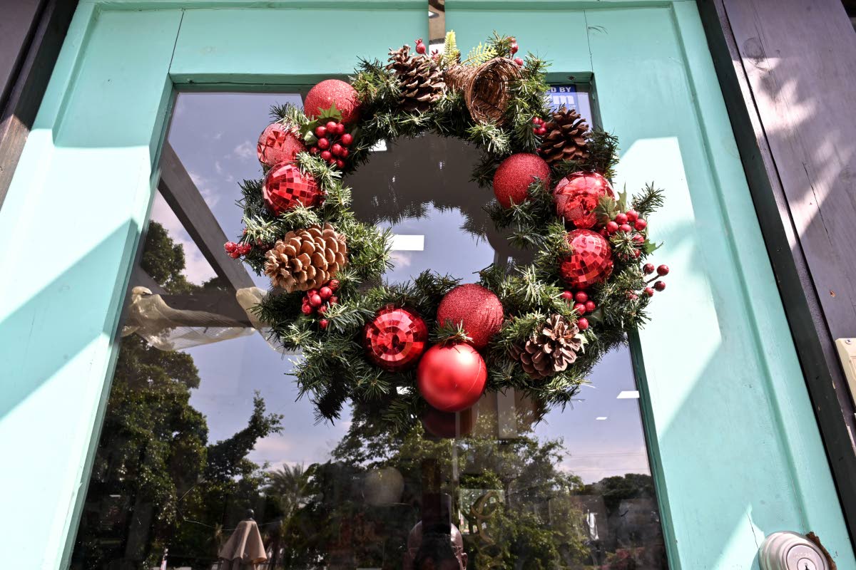 A Christmas wreath adorned with ornaments adds instant holiday spirit and is a simple styling trick. 
