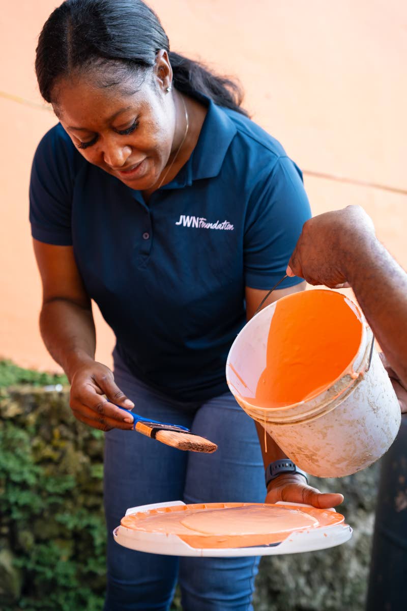 Keliesha Fearon, a resident of St Elizabeth and a JWN Foundation volunteer, prepares paint to help with the rebuilding efforts.