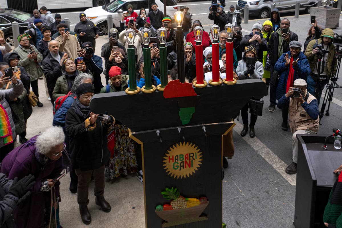 
Philadelphians and visitors gather during the the lighting of the city’s first kinara on the first day of Kwanzaa celebrations at the Philadelphia City Hall grounds on December 26, 2023.