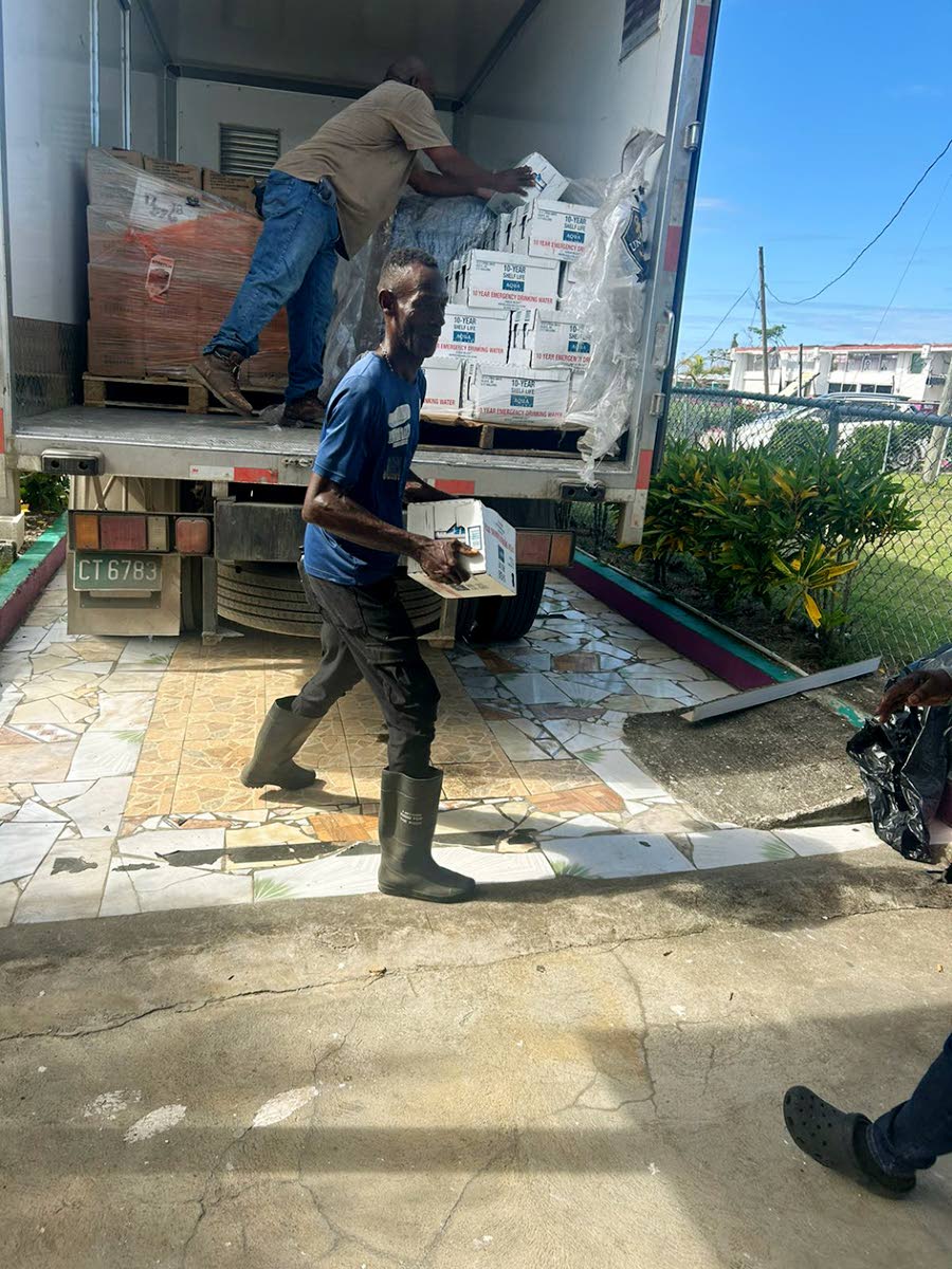 Volunteers unpack water and meals donated by Olympian Claston Bernard and the JN Foundation.