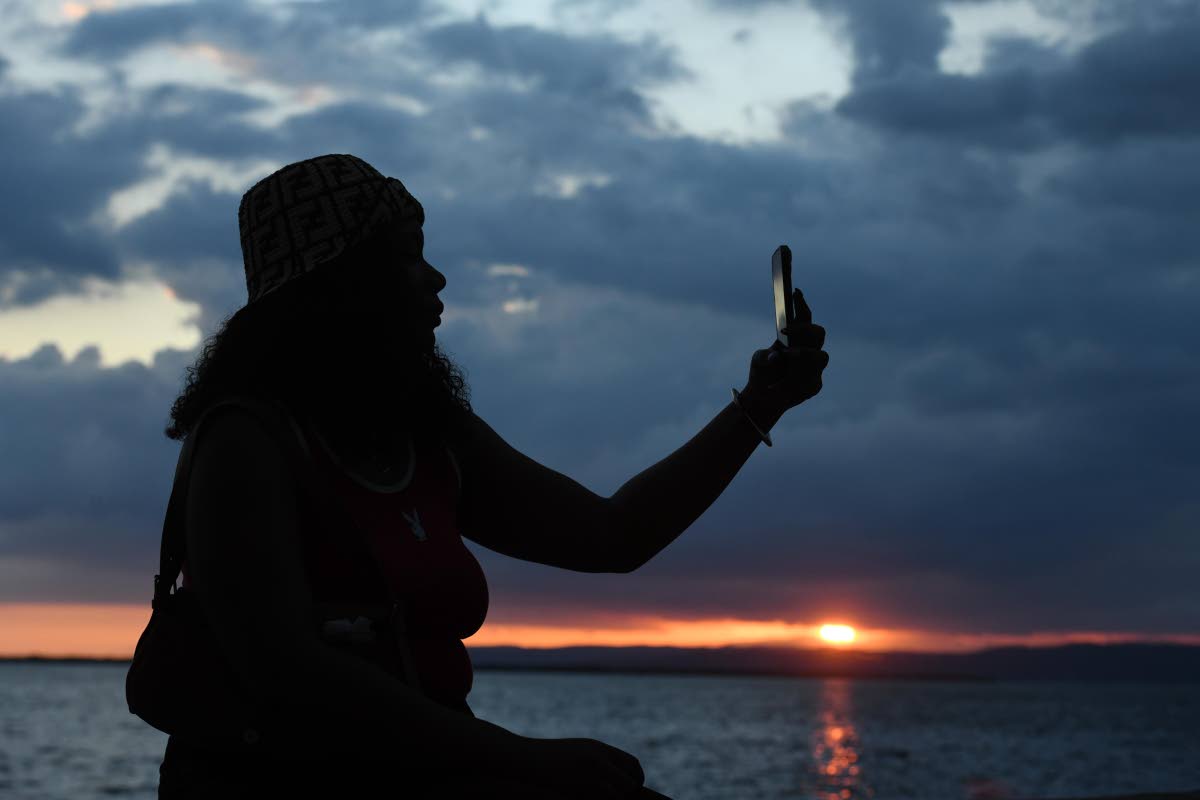 Kerry Mattocks takes a selfie with the final sunset of 2025 in the background.