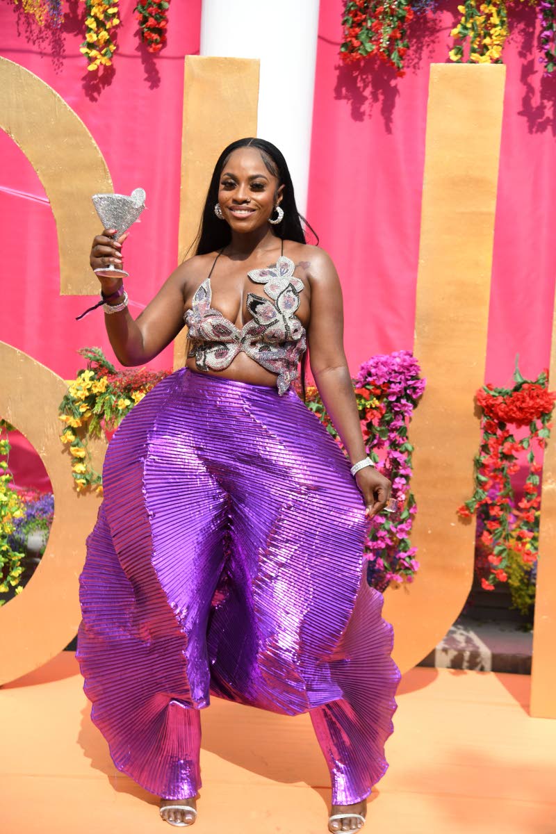 Regulatory specialist Jillesa Reid stands out in a vibrant purple ensemble that is both eye-catching and commanding. The sculpted top pairs seamlessly with the dramatic, textured pants, creating a look that feels powerful yet playful.