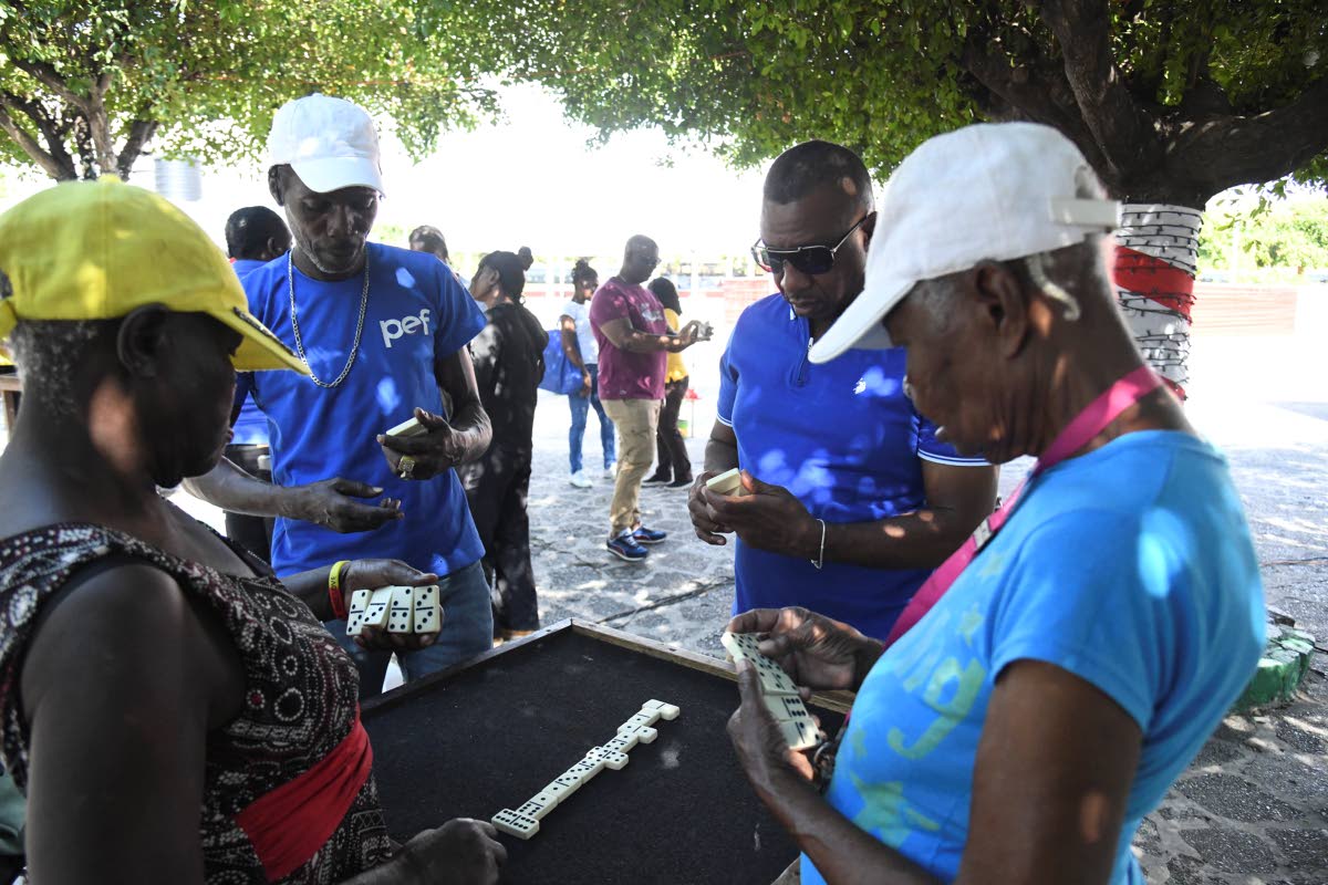 Mayor Andrew Swaby (second right) plays a game of dominoes with (from left) Beverley Cargill, Cavan Gooden and Esmerilda Graham inside the St. William Grant Park in Kingston on January 1, 2025.